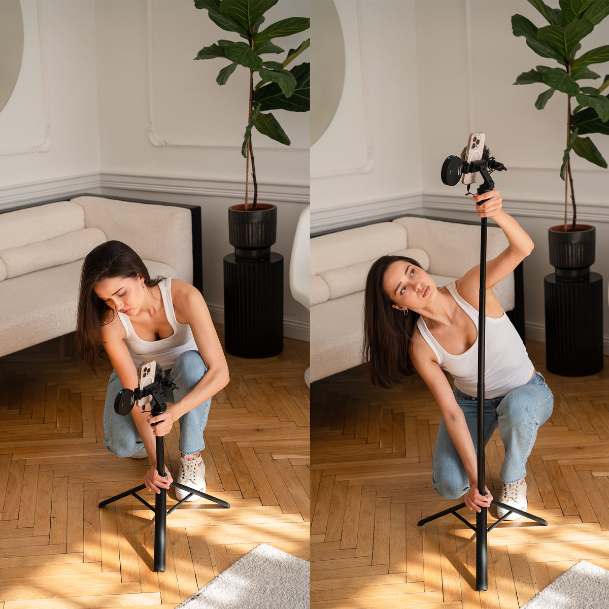 A woman in a white tank top and jeans demonstrates a handheld gimbal with a phone mounted on a tripod in a bright living room with wood floors and potted plants.