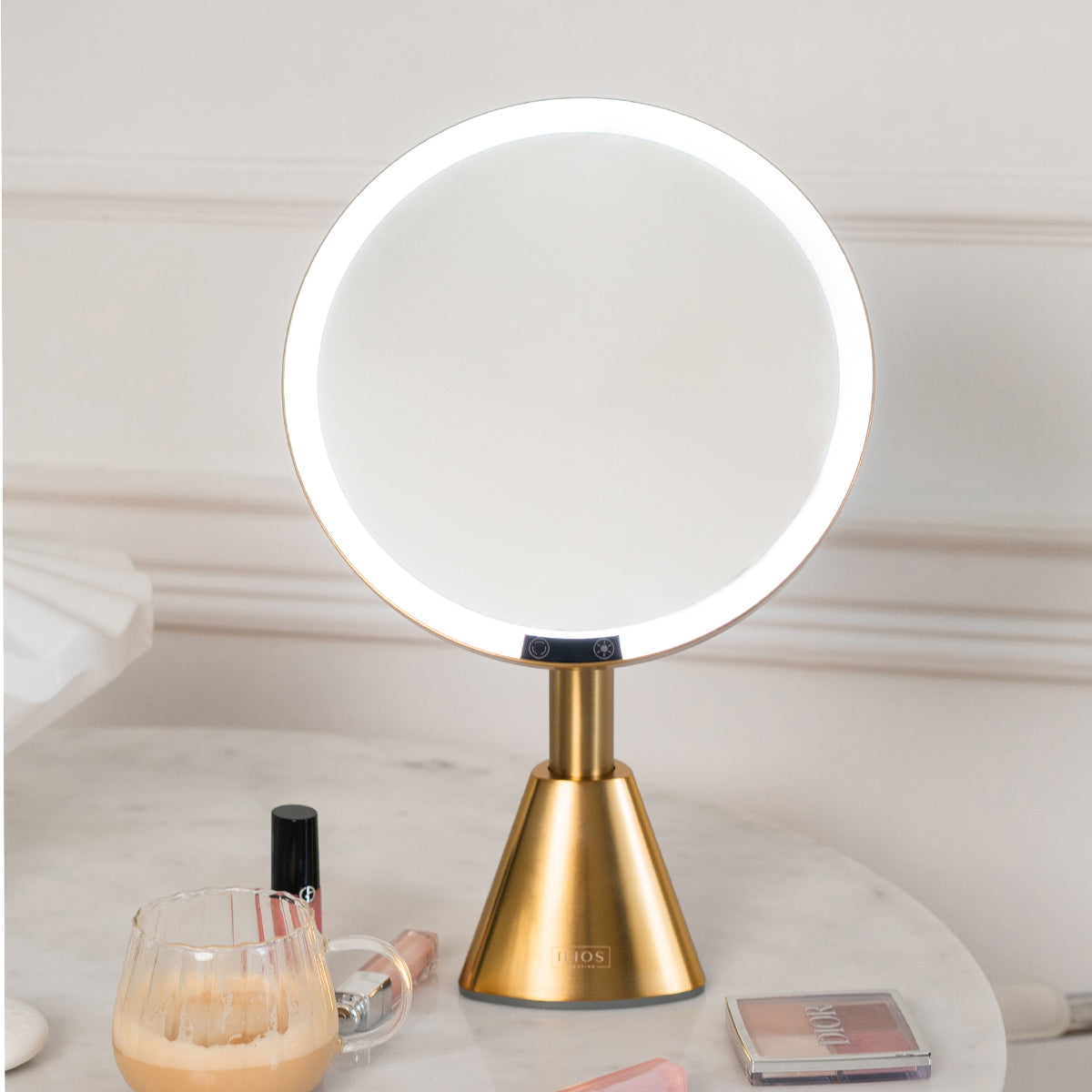 Gold vanity mirror with LED lights on a white surface