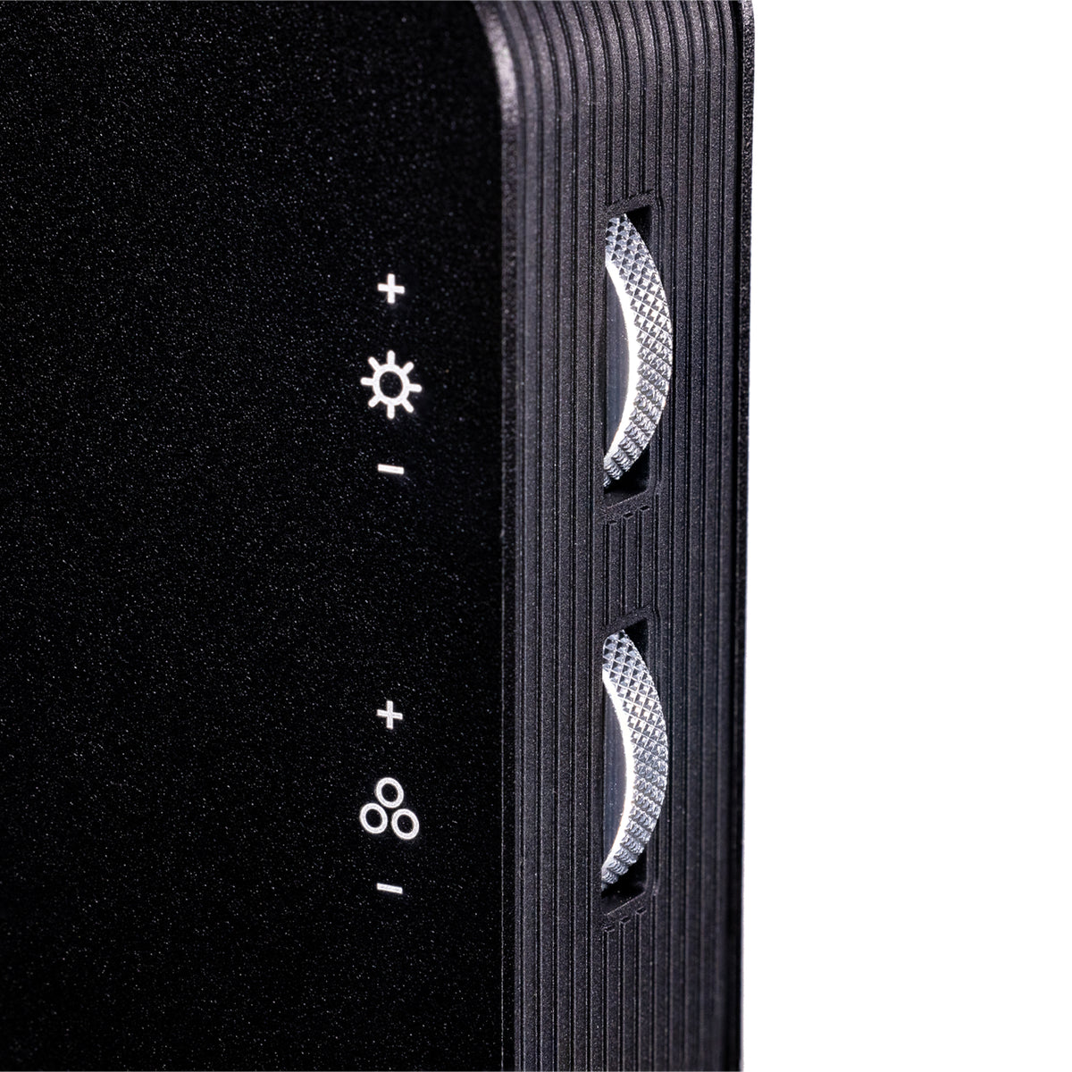Close-up of a black textured electronic device showing side controls with white icons for brightness, volume, and other settings, alongside two textured silver buttons, on a white background.